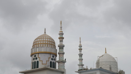 Fototapeta na wymiar Mosque dome with minaret with cloudy background 