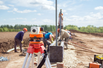 Construction equipment. Surveyors equipment theodolite on the construction site. Monitoring the progress of construction work.