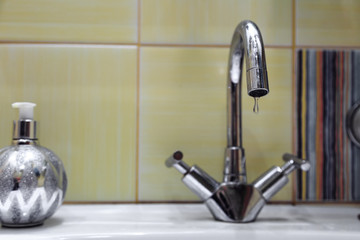 The crane is leaking. a drop of water drains from the tap. leaking plumbing.