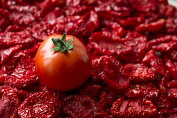 Close-up sun-dried tomatoes with spices and olive oil on wooden cutting board, background or concept, selective focus