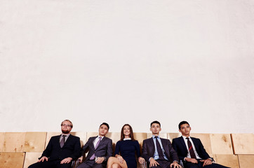 Full length portrait of a purposeful professional economists dressed in luxury clothes sitting in...