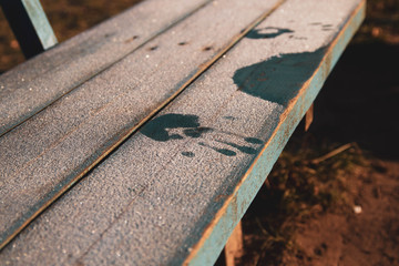 To freeze their legs from sitting on the cold bench in the Park. Cold, freezing. Winter background with handprints in the frost. Frost glistens in the sun.