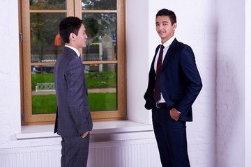 Young men international students dressed is elegant suit are talking about something, while are...