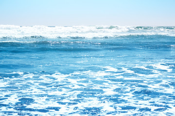 Blue ocean waves and yellow sand