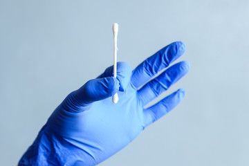 A cotton swab in the hands of a medic