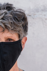 close-up of a look of a tired old woman with a mask preventing coronavirus
