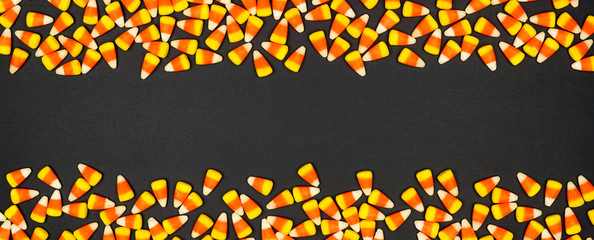 Halloween candy corn double border banner. Top view on a black background with copy space.