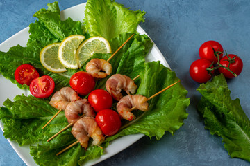 Tomato and shrimp shashlik baked in bacon. View from above.
