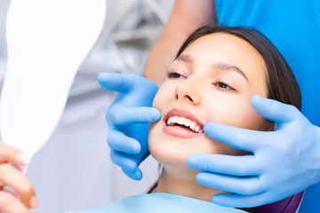 Young Female patient with pretty smile examining dental inspection at dentist clinic. Healthy teeth and medicine, stomatology concept