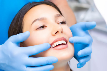 Young Female patient with pretty smile examining dental inspection at dentist clinic. Healthy teeth and medicine, stomatology concept