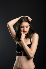 Vertical view photo beautiful shy lady in lace bikini boudoir bra panties. Tender skinny slim shape isolated black background.