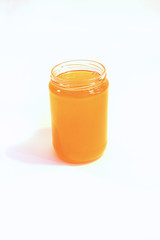 a jar of flower honey on a white background