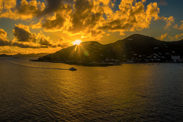 Fototapeta premium A boat returns to port in Road Town as the sun goes down in Tortola