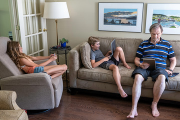 Grandfather and grandchildren enjoying their technology choice
