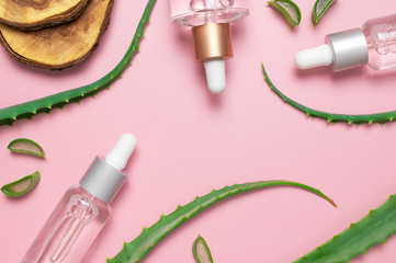 Organic cosmetics. Natural cosmetics concept. Cosmetic oil, serum, gel with aloe vera extract in glass container with pipette on pink background. Top view flat lay. Cosmetics SPA branding mock-up