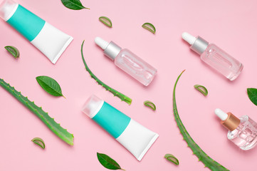 Organic cosmetics. Natural cosmetics concept. Cosmetic oil, serum, gel with aloe vera extract in glass container with pipette on pink background. Top view flat lay. Cosmetics SPA branding mock-up