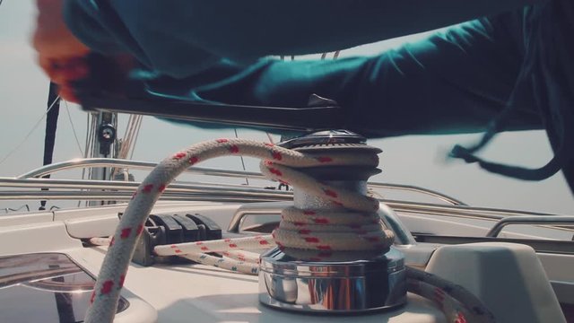 Man on the boat. Man works with winch on the sailing boat