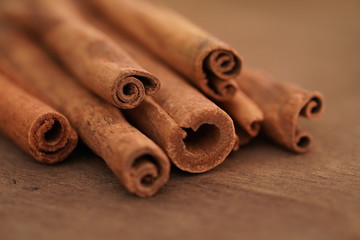 Selective focus, macro photo of cinnamon sticks on wooden brown background.Christmas time.Culinary spice for baking