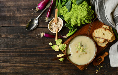 Romanesco cabbage or broccoli cream soup . cauliflower  soup on a wooden table.  fall seasonal menu. 