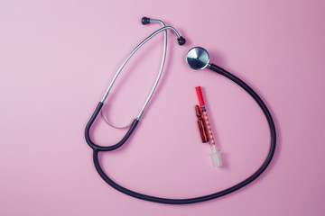 Pills, stethoscope and medical masks, vaccine on pink background.