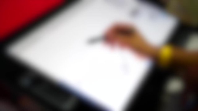 Blurred background. The man with his hand with special pencil drawing on tablet
