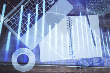 Financial market graph and top view computer on the desktop background. Double exposure. Investment...