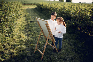 Little children in a summer park. Cute kids drawing