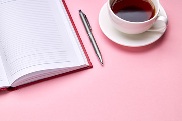 above view for pink desk with diary and tea cup on it. romance background backdrop