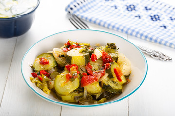 Steamed green zucchini dish on white background.