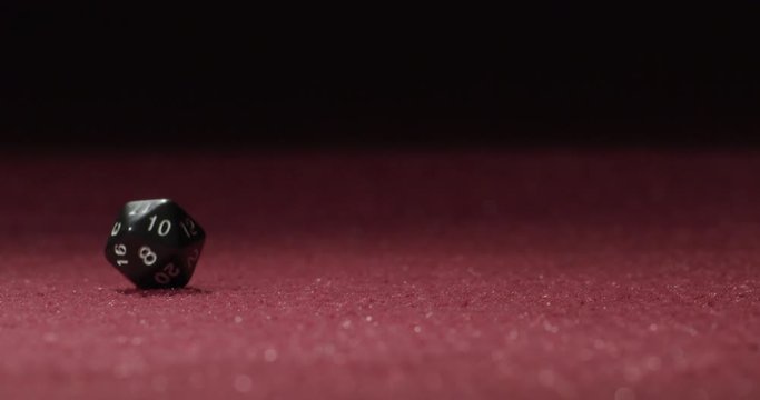 Close-up of Black 20-Sided Dice Rolling in Slow Motion Revealing 13 Side