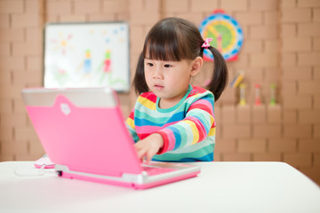 young girl using laptop for online learning during lockdown time