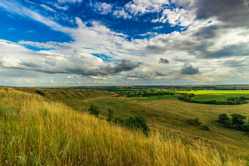 landscape photos of hills under clouds blue sky and green grass