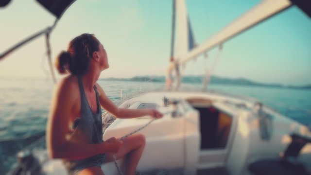Woman coils the rope. Young woman works with the rope on the sailing vessel and coils it