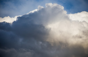Fluffy clouds cover the summer blue sky