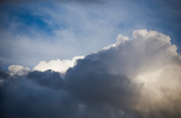 Fototapeta na wymiar Fluffy clouds cover the summer blue sky