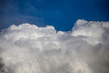 Fluffy clouds cover the summer blue sky
