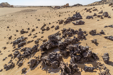 View over a sandy plain with isolated rock formations, Chad