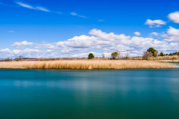 Landscape with lake and blue sky with white clouds
