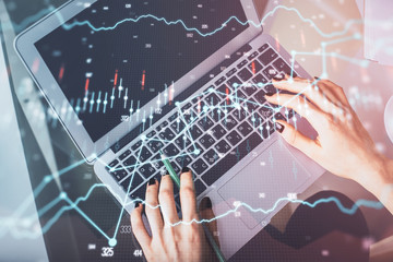 Double exposure of woman hands working on computer and forex chart hologram drawing. Top View. Financial analysis concept.