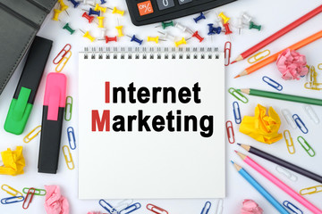 On the table is a calculator, diary, markers, pencils and a notebook with the inscription - Internet Marketing
