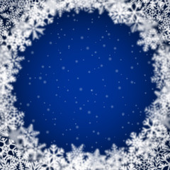 Christmas background of snowflakes of different shape, blur and transparency, arranged in a circle, on blue background