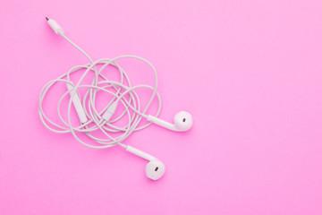 White tangle earphone on pink background. Copy space for text or design