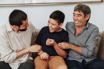 Male members of three generation family enjoying the day together in home