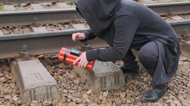 Woman terrorist laying explosives on railway. concept of terrorist act.