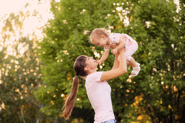 Happy family, mother and daughter are playing and laughing in nature in the park © Юлия Призова