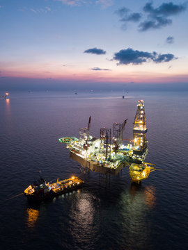 Aerial view offshore jack up rig at the offshore location during sunset with supply vessels and CPP