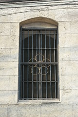 Fototapeta na wymiar Window with metal grill installed during Spanish era