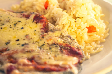 Delicious homemade plate of breaded meat with cheese and rice. Neapolitan Milanese with vegetables.