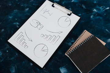 business analysis and statistics, desk with mixed graphs and charts on clipboard