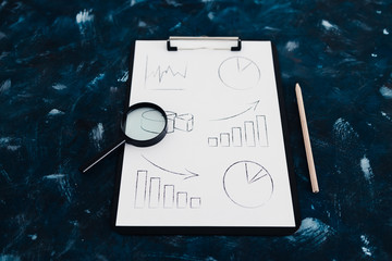 business analysis and statistics, desk with mixed graphs and charts on clipboard
